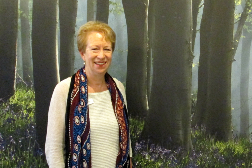 Lady standing in front of forest mural