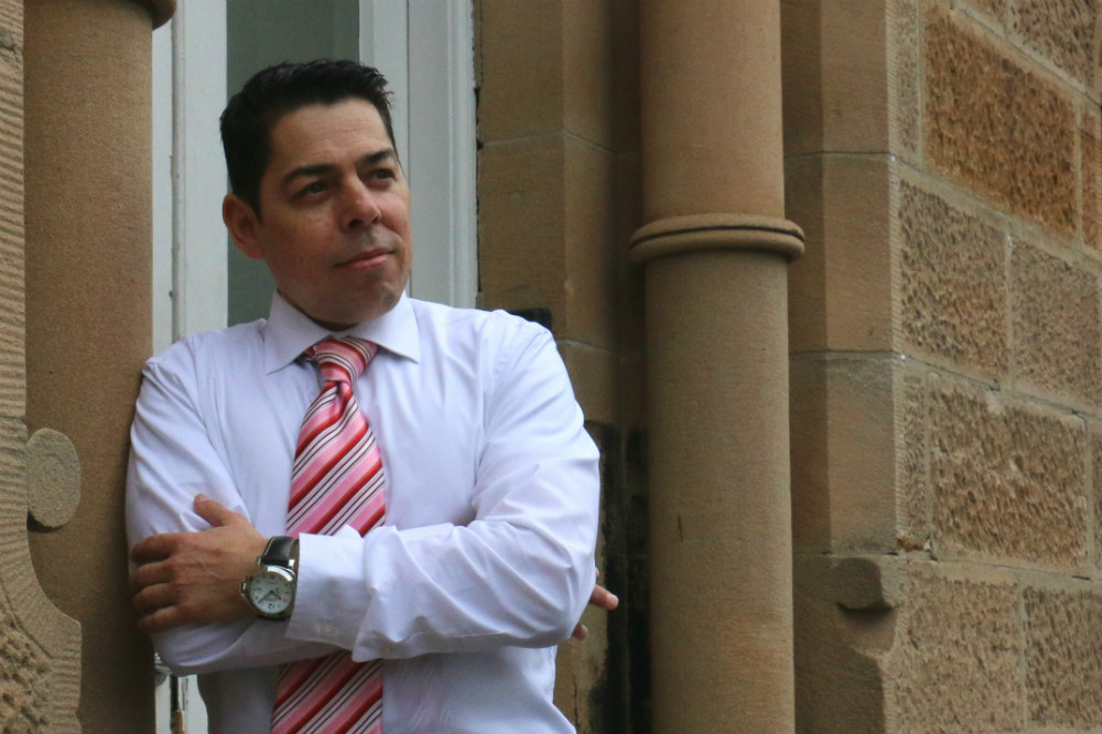 Man leaning on wall with arms crossed