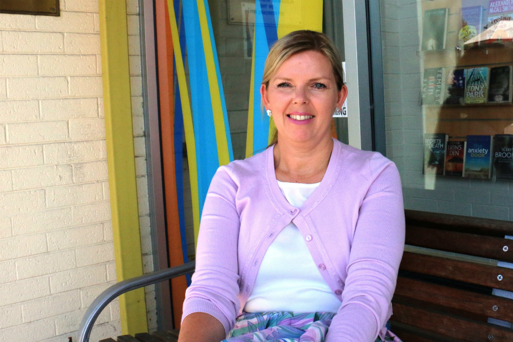 Woman in cardigan sitting on bench