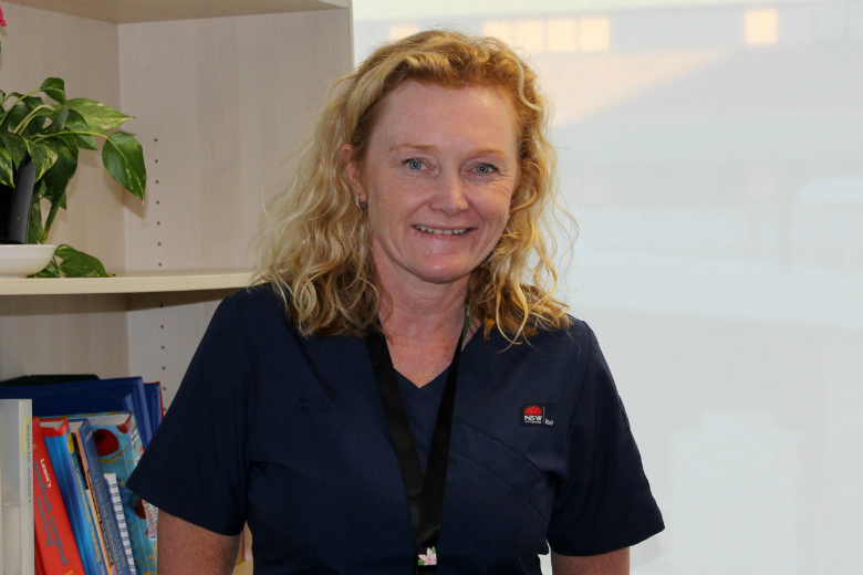 Nurse in front of bookcase and window