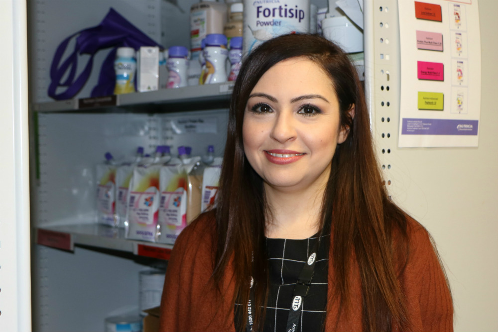 Smiling lady in front of cabinet