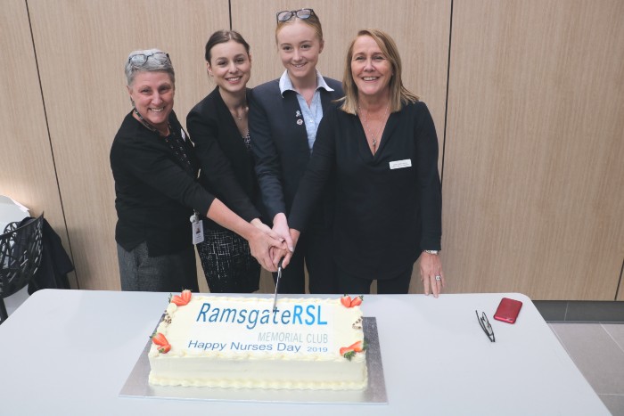 Nurses and midwives cutting a cake 