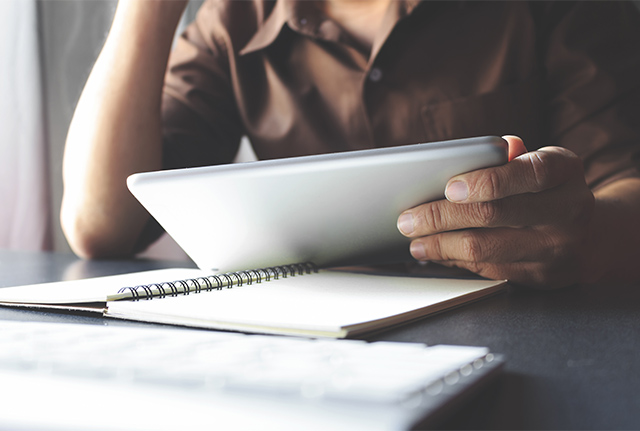 Close up of hands holding ipad on desk