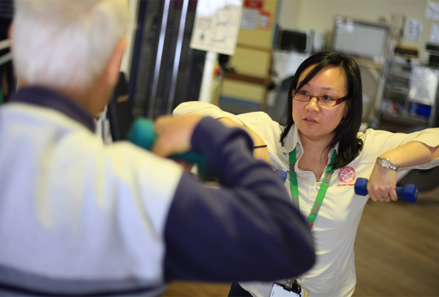 Clinician taking patient through weight exercise