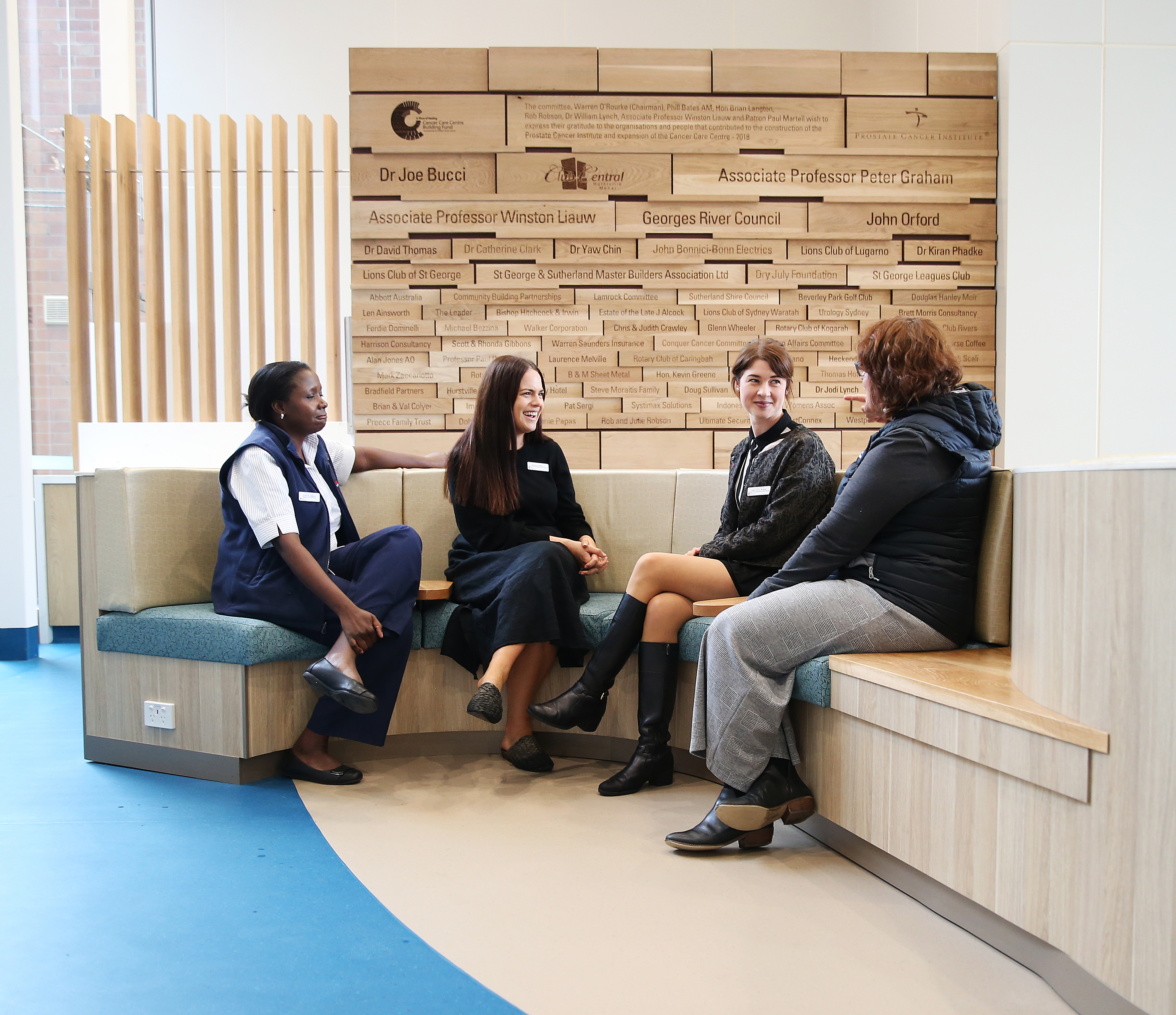 Group of four women sitting on couch chatting