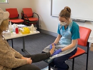 Staff member treats patient at wellbeing day.