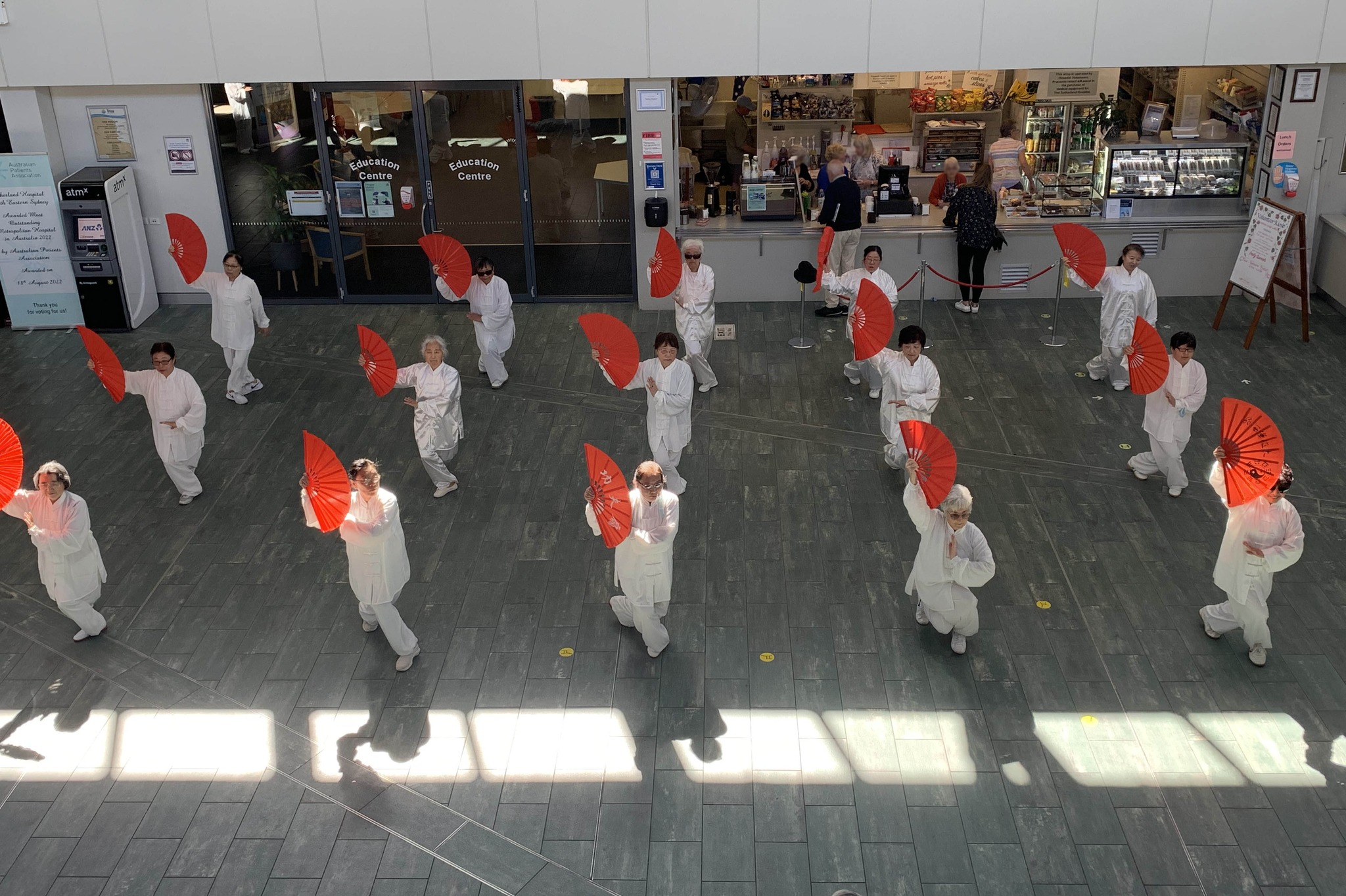 A tai chi group performing in the atrium of Sutherland Hospital