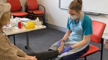 Staff member treats patient at wellbeing day.